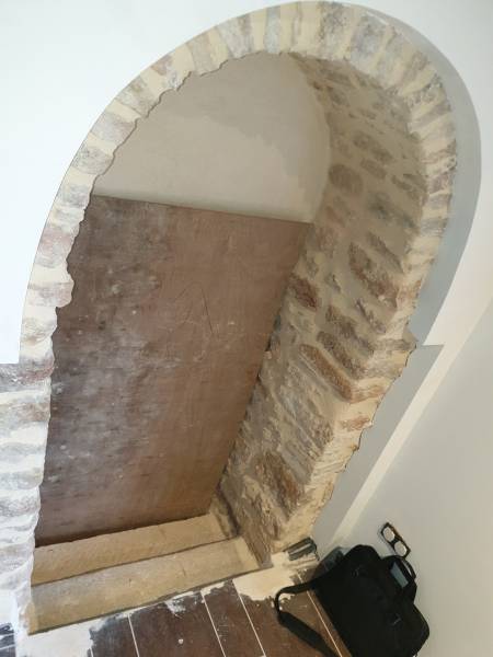 Porte originale en acier verre, voutée, pour un accès inférieur dans la commune de Saint Julien