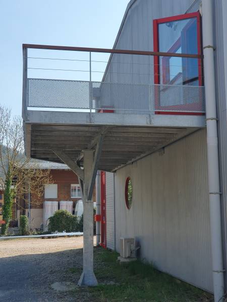 Réalisation d’une terrasse métallique industrielle avec renforts triangulés assurant stabilité et sécurité, même avec une structure reposant sur un unique point d’ancrage.