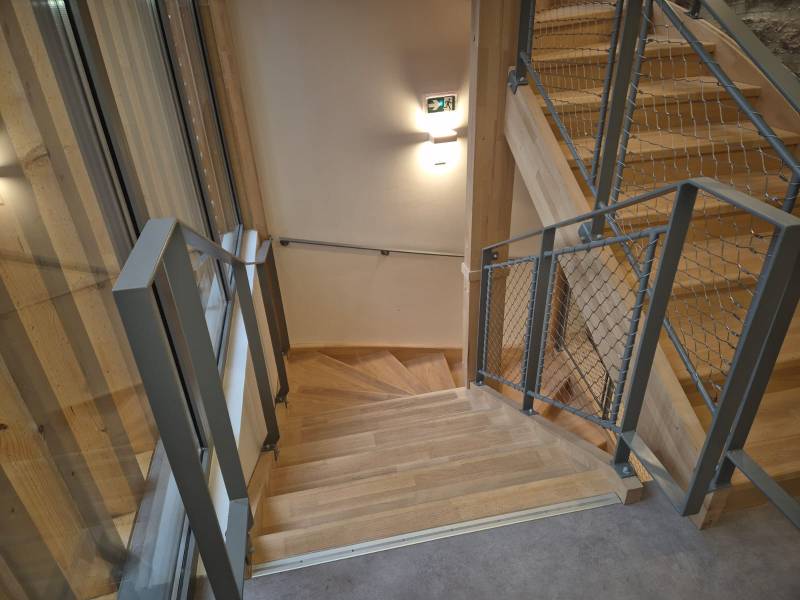 Garde-corps d'escalier en acier peint, alliant résistance et entretien facile pour ce bâtiment communal