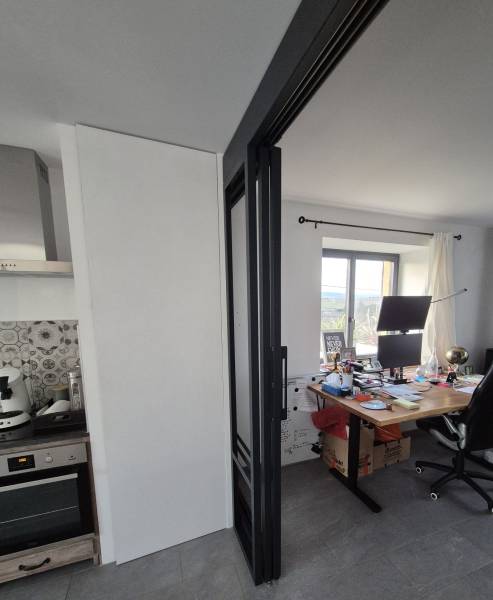 Détail d’une porte coulissante suspendue avec rails en applique design industriel