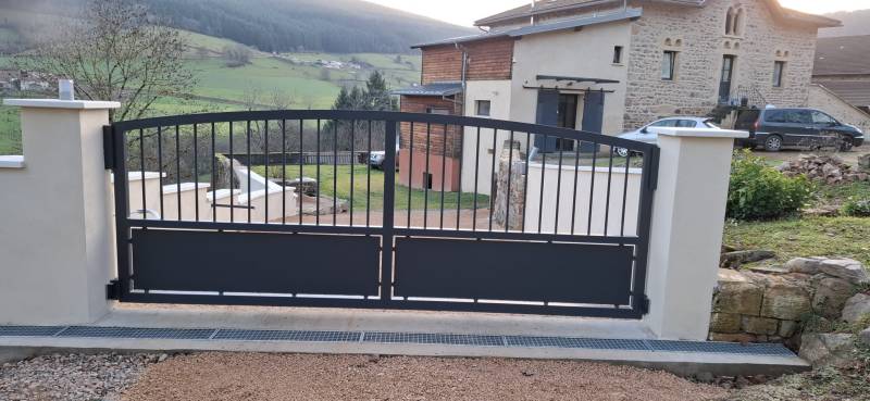 Portail acier sur mesure cintré, conçu et fabriqué par un artisan métallier, alliant robustesse, design haut de gamme et durabilité extérieure.